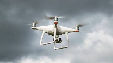 Drone dji Phantom 4 uçuşta. Bulutlu gökyüzüne karşı dron. Fırtına öncesinde drone uçuşu. Gökyüzünde helikopter uçağı.