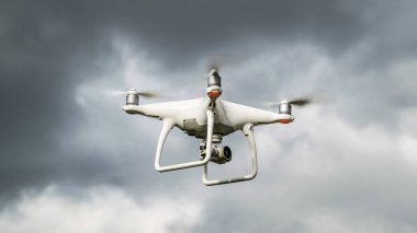 Drone dji Phantom 4 uçuşta. Bulutlu gökyüzüne karşı dron. Fırtına öncesinde drone uçuşu. Gökyüzünde helikopter uçağı.