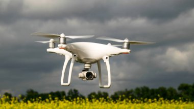 Çiçekli tecavüz alanında beyaz drone.
