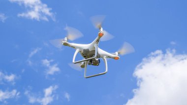İle DJI indeks işlem Phantom 4 uçuş robot. Quadrocopter beyaz bulutlar ile mavi gökyüzüne karşı. Gökyüzünde helikopter uçuş.
