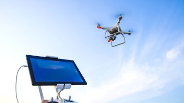 Quadrocopters ve onun için bir uzaktan kumanda. Mavi gökyüzüne karşı quadrocopters. Umravlenie quadrocopters