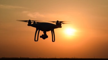 gün batımının arka planına karşı drone silüeti