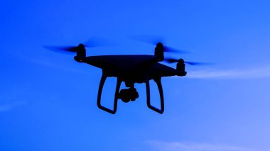Quadrocopters siluet güneşin arka planı. Akşam gökyüzünde uçan uçaklar