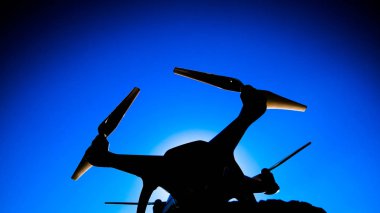 Quadrocopter Phantom 4 güneş mavi gökyüzünde karşı. Arka ışık. Dron yenilikçi bir uçan robot olduğunu.