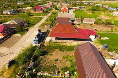 Bir gölgelik avlu üzerinde olan bir ev. Oluklu metal profil çatıdan. Metal kiremit.