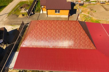 Bir gölgelik avlu üzerinde olan bir ev. Oluklu metal profil çatıdan. Metal kiremit.