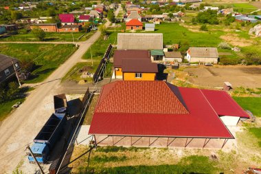 Bir gölgelik avlu üzerinde olan bir ev. Oluklu metal profil çatıdan. Metal kiremit.