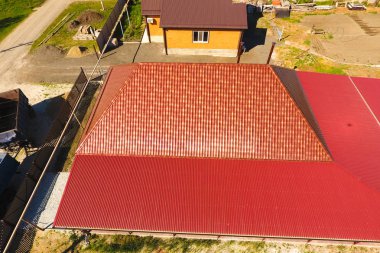 Bir gölgelik avlu üzerinde olan bir ev. Oluklu metal profil çatıdan. Metal kiremit.