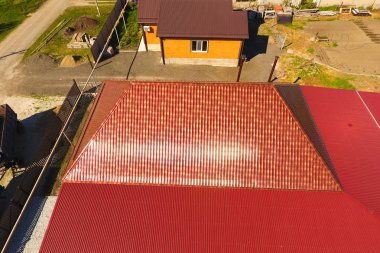 Bir gölgelik avlu üzerinde olan bir ev. Oluklu metal profil çatıdan. Metal kiremit.