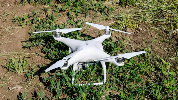 Weiße Drohne auf dem Boden mit Gras. — Stockfoto