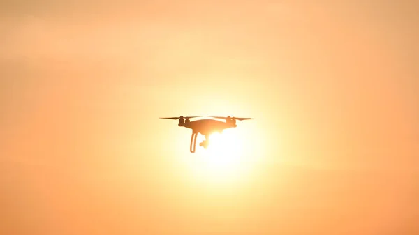 Silueta de dron contra el fondo de la puesta de sol —  Fotos de Stock