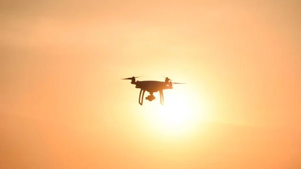 Silueta de dron contra el fondo de la puesta de sol —  Fotos de Stock