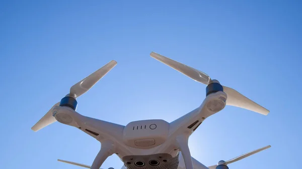 Quadrocopter Phantom 4 contro il cielo blu al sole. Retroilluminazione. Dron è un innovativo robot volante . — Foto Stock