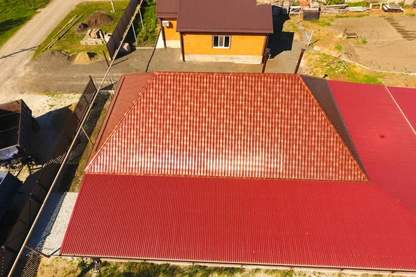 Een huis met een luifel op de binnenplaats. Dak van metalen golfgeprofileerde. Metalen tegels. — Stockfoto