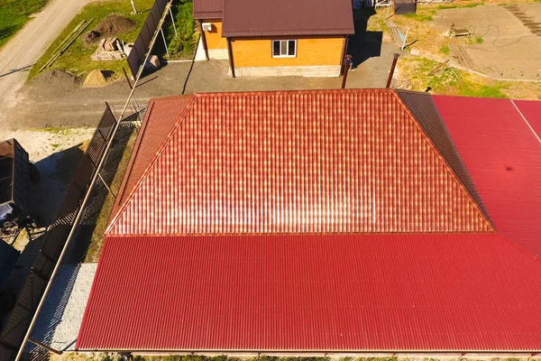 Bir gölgelik avlu üzerinde olan bir ev. Oluklu metal profil çatıdan. Metal kiremit.