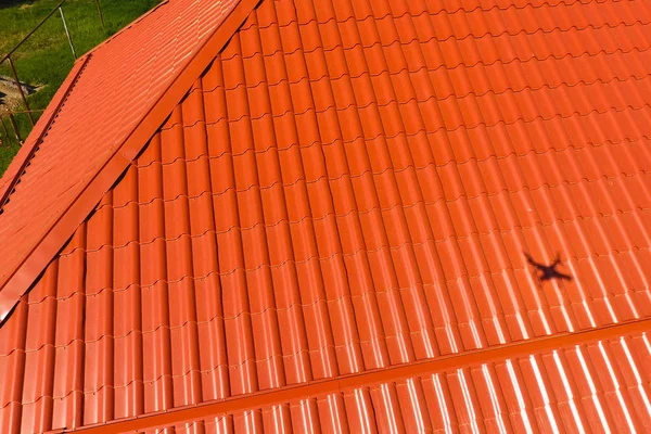 Casa con tetto arancione in metallo, vista dall'alto. Profilo metallico verniciato ondulato sul tetto . — Foto Stock