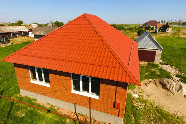 Hus med en orange tak gjorda av metall, top view. Metalliska profil målad wellpapp på taket. — Stockfoto