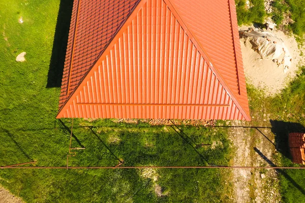 Casa com um telhado laranja feito de metal, vista superior. Perfil metálico pintado ondulado no telhado . — Fotografia de Stock