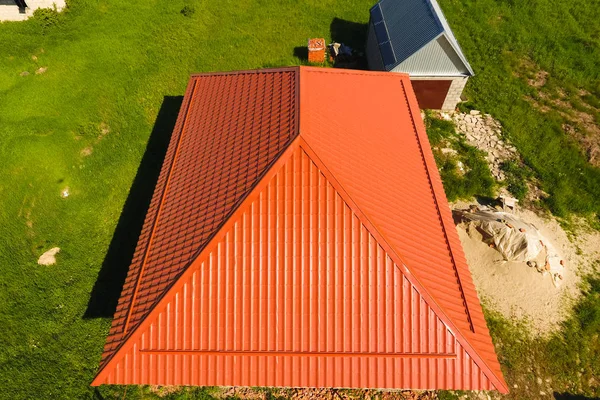 Casa con un techo naranja de metal, vista superior. Perfil metálico pintado ondulado en el techo . — Foto de Stock