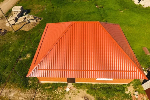 Woning met een oranje dak gemaakt van metaal, top uitzicht. Metalen profiel geschilderd gegolfd op het dak. — Stockfoto