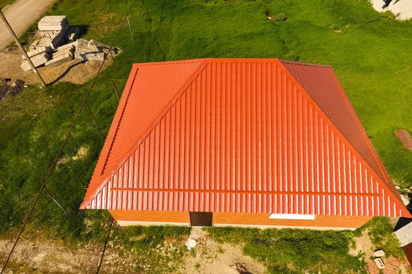 Σπίτι με πορτοκαλί στέγη κατασκευασμένη από μέταλλο, κορυφαία θέα. Μεταλλικά προφίλ ζωγράφισε κυματοειδές στη στέγη. — Φωτογραφία Αρχείου