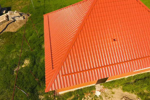 Дом с оранжевой крышей из металла, вид сверху. Металлический профиль окрашен гофрированными красками на крыше . — стоковое фото