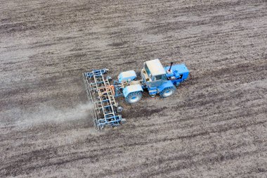 Traktör alan pulluklar. Ekim altında toprak sahada gevşetti.