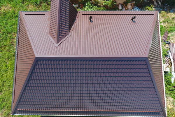 Вид сверху на крышу дома. Крыша из гофрированного листа. Крыша металлического профиля волнистой формы
