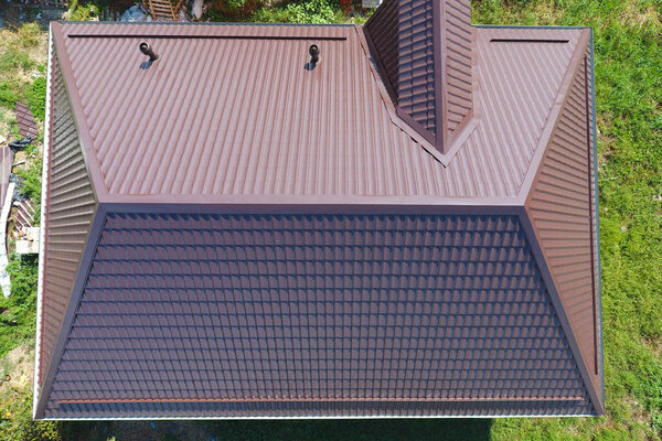 Вид сверху на крышу дома. Крыша из гофрированного листа. Крыша металлического профиля волнистой формы
