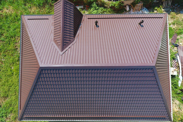 Вид сверху на крышу дома. Крыша из гофрированного листа. Крыша металлического профиля волнистой формы
