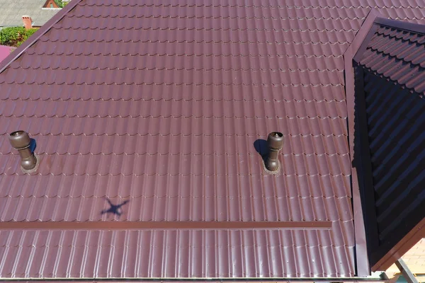 金属屋顶上的通风管道。瓦楞纸板的屋顶。金属型材波纹形屋面 — 图库照片