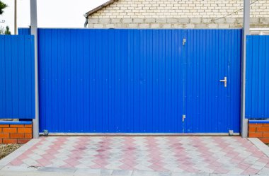 Çit ve kapı mavi oluklu metal yaprak.