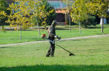 çalışan bir benzin fırça ile çim biçme. Düzeltici.