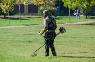 çalışan bir benzin fırça ile çim biçme. Düzeltici.