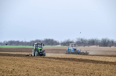 Gür ve Ekim önce toprak sahada gevşetin. Traktör bir alan ile bir pulluk pulluklar.