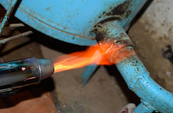 Отопление стальной трубы паяльной лампой. Пламя паяльной лампы — стоковое фото