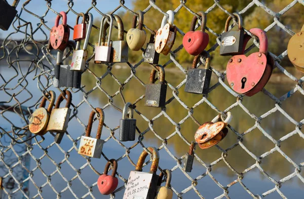 Serrures d'amour accrochées par les jeunes mariés et les amoureux sur la clôture près de la ri — Photo