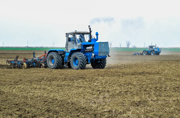 Bujna i spulchniają glebę, na pola przed siewem. Traktor orze pole z pług — Zdjęcie stockowe