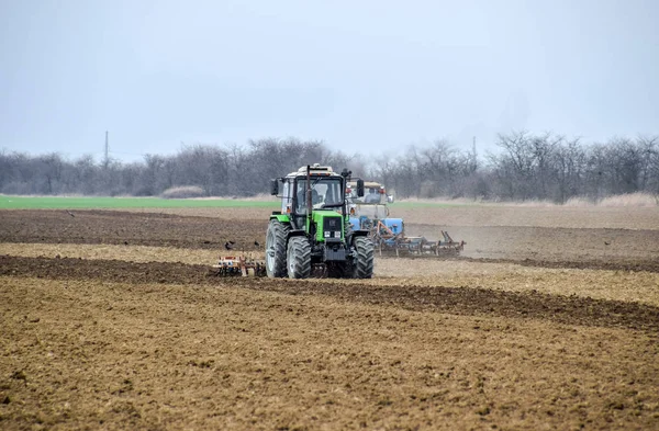 Bujna i spulchniają glebę, na pola przed siewem. Traktor orze pole z pług — Zdjęcie stockowe