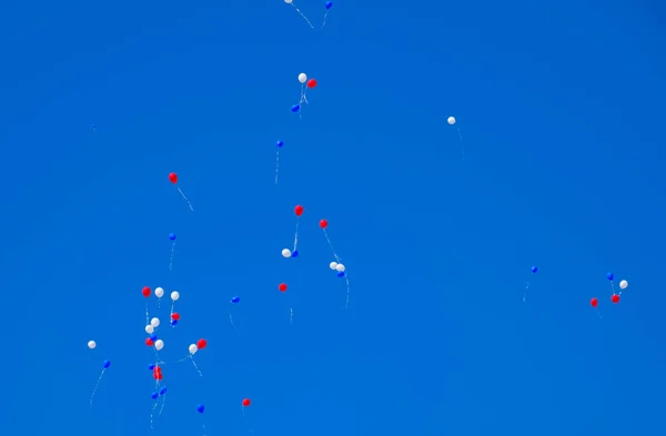 Bolas multicoloridas, cheias de hélio, voam no céu azul — Fotografia de Stock