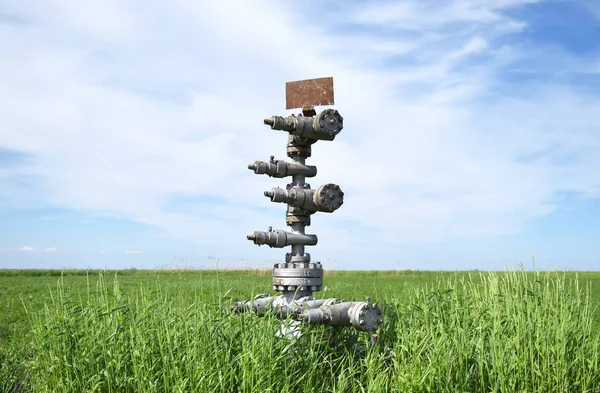 Konzervované ropný vrt proti obloze a pole — Stock fotografie