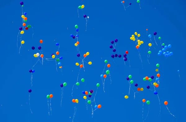 Bolas multicoloridas, cheias de hélio, voam no céu azul — Fotografia de Stock