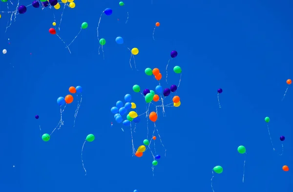 Helyum dolu çok renkli toplar mavi gökyüzünde uçar. — Stok fotoğraf