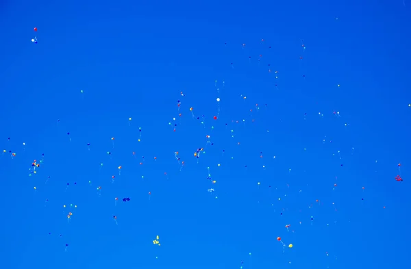 Bolas multicoloridas, cheias de hélio, voam no céu azul — Fotografia de Stock