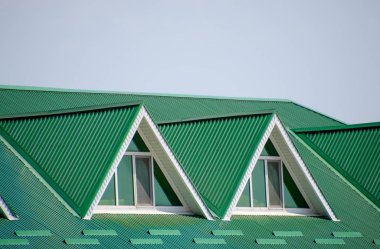 Plastik pencere ve oluklu levha yeşil bir çatı olan ev. Yeşil çatı oluklu metal profil ve plastik pencere.