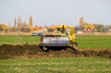 Zemin tesviye sarı traktör ile ekli grederom yapar.
