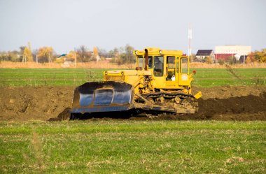 Zemin tesviye sarı traktör ile ekli grederom yapar.