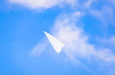 Mavi gökyüzünde bulutlar ile beyaz kağıt uçak. Messenger ileti simgesi