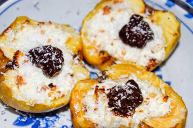 Elma süzme peynir ile pişmiş ve çikolata ve hindistan cevizi cips ile dekore.