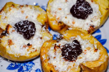 Elma süzme peynir ile pişmiş ve çikolata ve hindistan cevizi cips ile dekore.